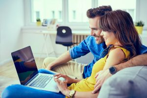 Image of a young couple on their laptop looking for expert mortgage and insurance advice